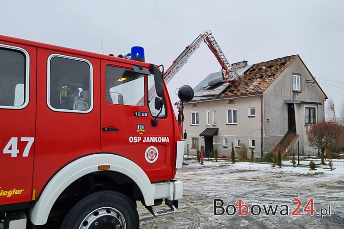 Silny wiatr zerwał blachę z dachu na domu w Jankowej. Strażacy zabezpieczają dach.